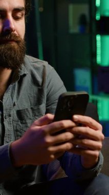 Dikey Videocu, gece geç saatlerde RGB 'deki akıllı telefondan arkadaşlarına mesaj atıyor. Arkadaşlarıyla sohbet etmek için cep telefonu kullanan kişi, sıcak neon ışıklı apartman dairesinde