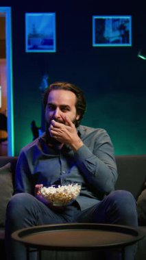 TV 'de film izlerken ve patlamış mısır yerken apartmanda yemek yiyen dikey videocu adam. Yemek yerken boğazı tıkanan, kanepede Heimlich manevrası yapan, onun için savaşan biri.