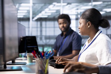 Veri merkezinde çalışan Afrikalı Amerikalı yönetici sistem tanılama testleri ve problemleri çözmek için hata kontrol araçları. Sunucu merkezindeki kadın platformların performansını etkileyen ağ sorunları arıyor
