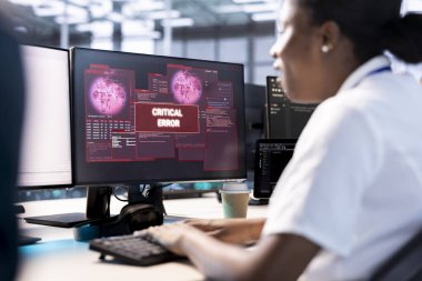 Sunucu merkezindeki Afrikalı Amerikalı bilgisayar bilimci ekipmanları hackerdan korumaya çalışıyor. Veri merkezindeki kadının güvenlik ihlali uyarısını düzeltmek için mühendislerden yardıma ihtiyacı var.