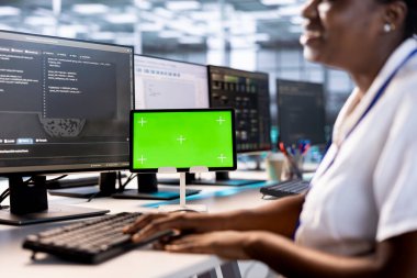 Veri merkezi süper bilgisayarlarında arıza olup olmadığını kontrol etmek için yeşil ekran tableti kullanan programcı. Sunucu çiftliğindeki zararları önlemek ve sistemleri izlemek için model cihazı üzerinde çalışan kadın