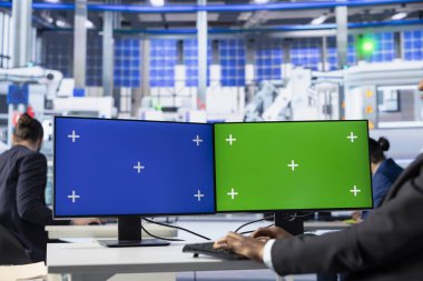 Güneş panelleri, izole ekran PC kullanarak enerji tüketimini denetleyen fabrika mühendisi. Fotovoltaik tesisi çalışanı, bilgisayar monitörleri kullanarak imalat kaynaklarının optimum kullanımını sağlıyor