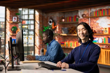 Müşteri araçlarına bağlanmak için bilgisayardaki uzaktan erişim araçlarını kullanan neşeli çağrı merkezi ajanının portresi. Neşeli Asyalı müşteri merkezi, yazılım yükleme konusunda profesyonel yardımcı müşteriler