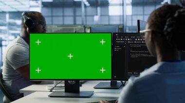 Bilgi işlem uzmanı, yeşil ekran PC kullanarak tehditlerden korunan değerli verileri sağlıyor. Bir kadın, kamera A 'yı kullanarak izinsiz erişime karşı donanımı koruyor.