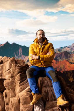 Erkek yürüyüşçü kayalıklardaki nefes kesici dağ manzarasını izler, manzaralı arka plan, temiz hava ve engebeli zirvelerin tadını çıkarır. Refah için yeni ufuklar keşfetme heyecanı.