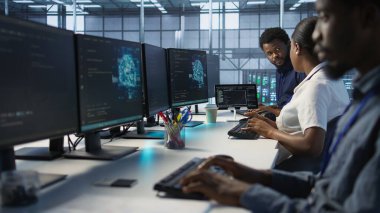 Bilgi işlem uzmanları beyin fırtınası yapıyor, şirket ağ altyapısını koruyor. Sunucu merkezi bilgisayar uzmanlarından oluşan bir ekip sohbet ediyor, optimal sistem performansını sağlıyorlar, kamera A