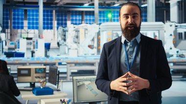 Güneş paneli fabrikası uzmanı, gelişmiş üretim ekipmanları ve yenilenebilir enerji çözümlerinin altını çizerek turneye çıkıyor. Endüstriyel tesislerdeki adam yeşil enerji üretim sürecini sunuyor, kamera A