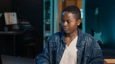 Girişimci evde çalışıyor, dizüstü bilgisayar kullanıyor ve kağıda notlar yazıyor. Kişisel apartman dairesindeki uzaktan çalışan, e-postaları cevaplayan ve not defterine önemli bilgiler yazan, kamera A