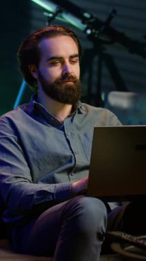 Dikey videocu dizüstü bilgisayarda klavye kullanıyor, neon ışıklı dairede, koltukta oturuyor ve patlamış mısır kasesiyle televizyon seyrediyor. Not defterindeki görevleri çözen ve içinde film olan telesekreter kişi