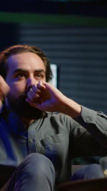 Dikey video aşırı sevinçli bir destekçi maç yayınını izliyor, sevinçten havalara uçuyor, takımın kazanmasından memnun. Mest olmuş bir adam TV 'de futbola bakıyor, çılgınca jestler yapıyor, golü görüyor.