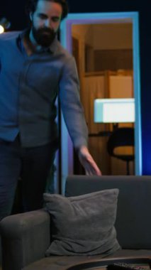 Vertical Video Neşeli Oyuncu yeni çıkan oyunu oynamak için eve koşuyor. Kanepede zıplayan mutlu bir adam, konsolda video oyunu oynamaya hevesli, zor bir günün ardından dinleniyor, kamera B yavaş çekim