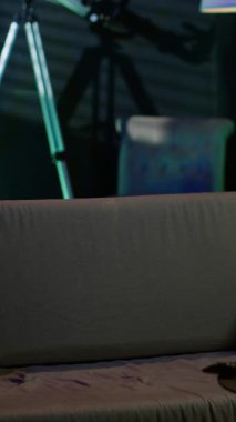 Dikey Videocu televizyon izlemek için kanepede oturuyor, rahat ev ortamında eğleniyor. Daireye gelen kişi kanepeye oturur, filmlerden zevk alır, televizyonu açar, yemek yer.