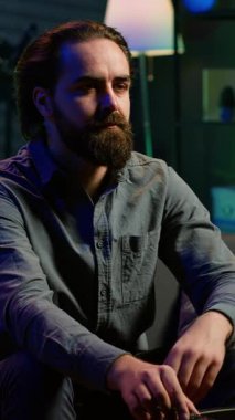 Dikey Videocu, evde kanepede dinleniyor. Evde televizyon izlerken ağzına patlamış mısır tıkıyor. Abur cubur yiyen ve neon ışıklı oturma odasında TV şovları yapan kişi, kamera A