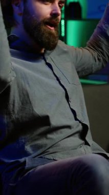 Takım performansından rahatsız olan ve hayal kırıklığı içinde televizyonu kapatan dikey video taraftarı spor maçı izliyor. Futbol müsabakasına bakan somurtkan adam, hakem kararından dehşete düşmüş, kamera A