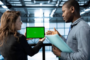 Veri merkezinde modelleme tableti kullanan, analitik gözlemleyen, altyapı sağlığını inceleyen yöneticiler. Sunucu merkezi bilişim çalışanları tartışıyor, kroma anahtar aygıtı kullanıyor, sistem parametrelerini ayarlıyor