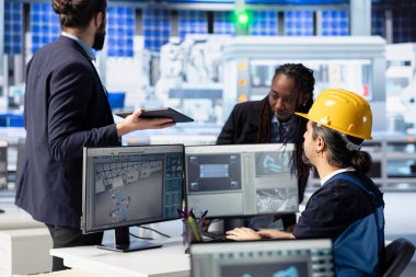 Fotovoltaik fabrikası mühendislik ekibi beyin fırtınası yapıyor, işlevsel yetersizlikleri belirlemek için sistem kayıtlarını inceliyor. Güneş panelleri imalat parametrelerini ayarlayan iş arkadaşları