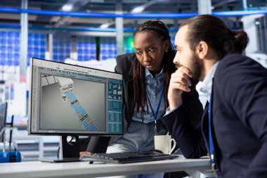 Güneş paneli çalışanları konuşuyor, işbirliği yapıyor ve fotovoltaik sistem performansını inceliyor. İş arkadaşları verimliliği optimize etmek için endüstriyel fabrikada beyin fırtınası yapıyor, üretim ölçümlerini analiz ediyor.