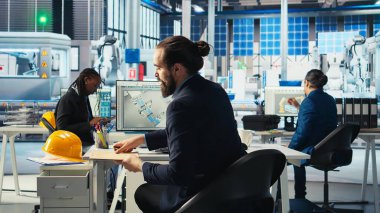 Sürdürülebilir enerji fotovoltaik fabrikasındaki teknisyen bozuk sistemleri teşhis ediyor. Güneş panelleri fabrika personeli üretiyor. Sistem güvenilirliğini yüksek seviyede tutmak için çalışıyor.