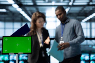 Çalışanların önündeki yeşil ekran tabletini kapatın sunucu odasını denetleyin, evrak okuyun, sorun çıkaran aletler kullanın. Sunucu merkezi çalışanlarının yanında teknik dosyaları okuyan bir model aygıtı