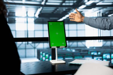 Veri merkezinde izole ekran tableti kullanan mühendisler, sunucu viralizasyonunu yönetiyorlar. Sunucu odasında uzun vadeli altyapı güvenilirliğini sürdürmek için modelleme aygıtı kullanan işçiler