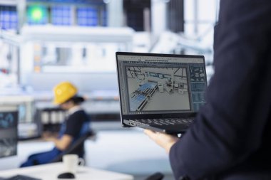 Fotovoltaik fabrikası teknisyeni güneş paneli tasarımlarını test etmek için dizüstü bilgisayar kullanıyor. Çalışan, defter kullanarak maliyet azaltma için mevcut güneş paneli ayarlarını geliştiriyor, kapat