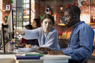 Çağrı merkezi, bilgisayar yazılımının nasıl kullanılacağı konusunda uzman eğitimci. Müşteri destek biriminde yönetici stajyere şirket başvurusunun nasıl kullanılacağını gösteriyor.