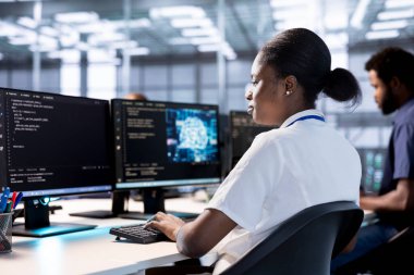 Sunucu çiftliği bilişim uzmanı yapay zeka araştırması yapıyor, sinirsel ağları kullanarak algoritmalar yaratıyor ve uyguluyor. Veri merkezindeki Afrikalı Amerikalı kadın yapay zeka hesaplama modelleri kullanıyor.