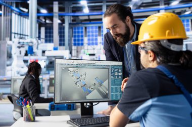 Güneş panelleri fabrika yöneticisi ofiste kalite kontrolü yapıyor, yüksek verimliliği sağlıyor. Fotovoltaik fabrikası denetleyicisi robot silah kalibre çalışanı tarafından yapılan çalışmaları kontrol ediyor