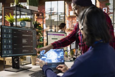 Yardım amaçlı yapay zeka araçları üzerine yeni ajan yetiştirme uzmanını ara. Müşteri destek bürosundaki Afrikalı Amerikalı yönetici, insana şirket yapay zeka yazılımının nasıl kullanılacağını gösteriyor.