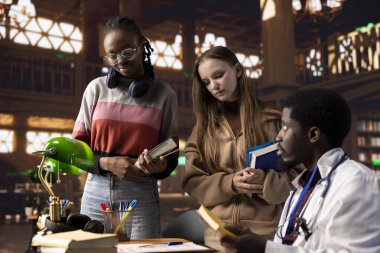 Tıp diploması alan üniversite öğrencileri, kampüs kütüphanesinde tıp alanında uzman doktorlarla birlikte, eczacılık ve cerrahi eğitimin ilerletilmiş konularını öğrenmek için özel dersler veriyorlar..