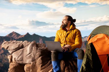 Teknoloji düşkünü bir yürüyüşçü bir teknoloji saplantısı var ve bir dağ zirvesinde çalışıyor, her zaman güçlü sinyallerle internete bağlı. İşkolik gezgin bir tepede uzaktan kumandalı iş yapıyor..