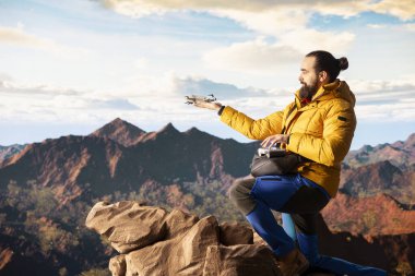 Seyahat meraklısı, insansız hava aracı görüntüleriyle onun faaliyetlerini yakalıyor. Manzaralı dağ aralığı vadisini belgeliyor. Uzaktan kumandalı güzel hava görüntüleme vlog 'u çekiliyor.