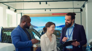 Araba galerisi satıcısı müşterilerle anlaştıktan sonra evrakları ve belgeleri tamamlıyor. Ajans, müşterilere araç anahtarı ve kamera A 'yı verdikten sonra imzalamaları için satış sözleşmesi veriyor.