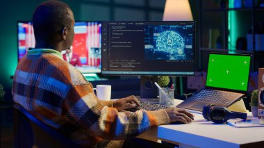 Afrika kökenli Amerikalı bir adam yapay zeka kullanarak bilgisayar üzerinde kroma anahtarı olan bir yazılım sistemi geliştiriyor. Erkek bilişim programcısı kodlama, siber güvenlik ve makine öğrenme yeteneğini gösteriyor. Kamera A.