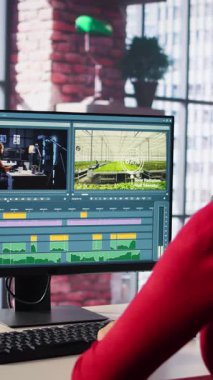 Ajans ofisinden medya prodüksiyonu üzerine çalışan dikey video kadın film yapımcısı, video çekimi için kurgu zaman çizelgesi ve renk düzeltmesi sağlıyor. Teknoloji güdümlü çalışma alanı iş akışını gösterir