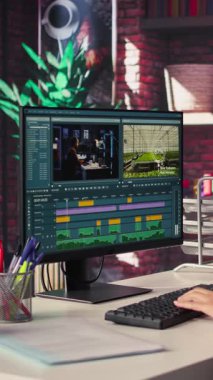Dikey Video Klipçi kadın çatı katındaki çift monitörlerde bir müzik videosu düzenliyor, zaman çizgisi düzenleme ve renk derecelendirme arasında birden fazla iş yapıyor. Profesyonel düzenleyici teknoloji araçları ve yazılım kullanır