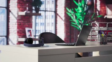 Minimalist boş bir masa içeren zarif, modern bir çatı katı dairesi. Parlak ferah ve şık, lüks ev ofisi şık mobilyaları ve açık tasarımı birleştirerek sofistike sakin bir ortam yaratıyor..