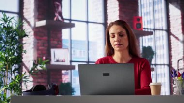 Kendine güvenen bir kadın evdeki serbest bir platformda görevlerini çözüyor, e-postaları cevaplıyor ve birden fazla iş yapıyor. Olgun işçi bağlı kalır ve uzaktan çalışmanın esnekliğinin tadını çıkarır. Kamera A.