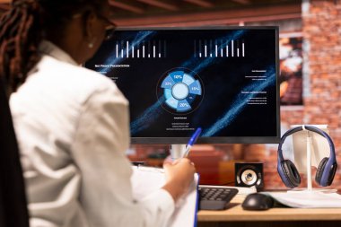 Kariyer geliştirmek için online öğrenim yapan öğrenci sunumu izlerken not alıyor, kapanıyor. Bilgisayar ekranındaki internet seminerinden bilgi toplayan kadın