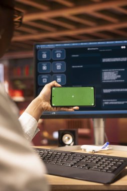 Yapay zeka sohbet robotlarıyla ilgili video derslerine bakmak için cep telefonu kullanan bir kadın, yakın plan. Yapay zeka LLM 'lerindeki görsel rehberlere bakmak için elinde krom anahtarı olan kişi.
