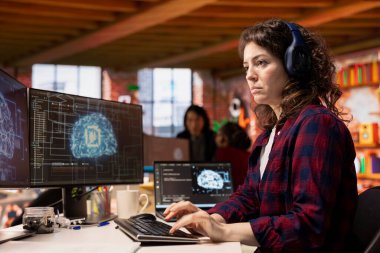 Kulaklık takan bilişim mühendisi AI teknoloji ajansında özel yazılım geliştirme hizmetleri sunuyor. IT uzmanı müzik dinliyor, kodlama sürecini düzene sokmak için yapay zeka teknolojisi kullanıyor