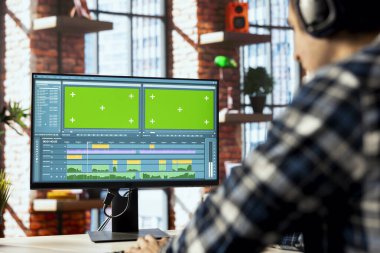 Video düzenleyicisi video segmentlerini buduyor, kroma anahtar bilgisayar kullanarak promosyon klipleri üzerinde çalışıyor. İzole edilmiş ekranda profesyonel yazılım kullanarak film parçalarını birleştiren, düzenleyen kameramanların kapatılması
