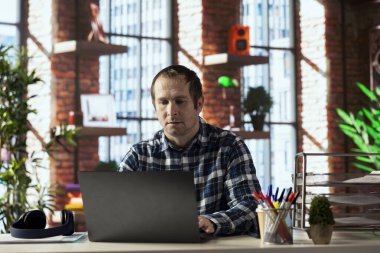 Ofiste masa başında oturan ve dizüstü bilgisayarda klavye çalan serbest çalışan biri. İnternet üzerinden müşteri ilişkileri işi yapmak için elektronik aygıt kullanan uzak bir çalışan, sorulara yanıt veriyor