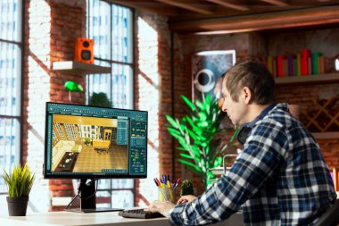 İç mimar masada oturuyor bilgisayarda 3D modelleme yazılımı kullanıyor, mobilyaların yerini değiştiriyor. Mimari tasarımcı ögeleri konumlandırır, müşteri onayı için yapılandırmayı kaydeder