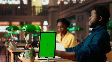 Siyahi üniversite öğrencileri ders notlarını fotokopi makinesinin yanında okurlar, kampüs kütüphanesinde birlikte çalışırlar. Öz gelişim ve eğitim üzerine çalışan öğrencilerden oluşan bir ekip, çalışma zamanı. Kamera B.