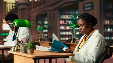 Tıp fakültesinde oksitölçer kullanan siyahi bir kız öğrenci ve uygulamayı okuyor, kütüphanede akademik veritabanı fotokopi kitaplarıyla çalışıyor. Bilgin tıbbi araştırmasını yapıyor. Kamera B.