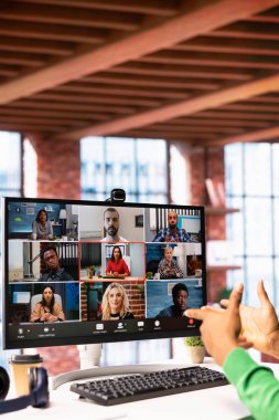 Evrakları inceleyen, iş vardiyalarını düzenleyen, video görüşmeleri sırasında çalışanlarla konuşan bir yönetici. Denetmen, personelle uzaktan telekonferans toplantısı yapıyor, belgeleri kontrol ediyor.