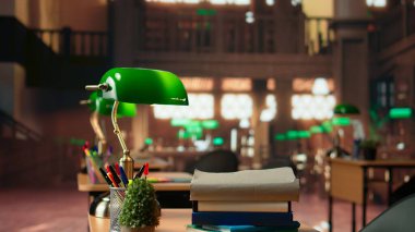 Ahşap raflar ve klasik yeşil lambalar içeren boş eski bir kütüphane, eski moda zarif mobilyalar öğrenme ve entellektüel gelişime ilham vermek için sakin bir çalışma alanı oluşturur.