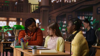 Çeşitli liseli kızlar, profesörlerle birlikte bir okul kütüphanesinde kompozisyon yazmaya odaklanmış, ekran modelinin yanında ev ödevleri üzerinde çalışıyorlar. Bilginler ders kitaplarındaki ödevlerini tamamlıyorlar. Kamera A.