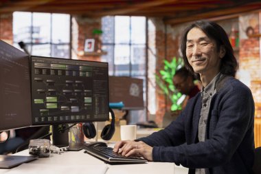 Başlangıç ofisinde bilgisayar kullanarak makine öğrenmesini sağlayan algoritmalar tasarlamak ve uygulamak için mutlu CTO yöneticisinin portresi. Neşeli teknoloji girişimi kıdemli teknisyen hataları düzeltmek için kod incelemeleri yapıyor.